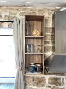 a kitchen with a shelf with cups and a laptop at Casa Rapata in Gaios +28 photos