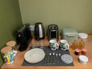 a table with a coffee maker and plates and cups at Chambre en Drôme Tropicale in Chabeuil