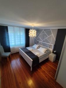 a bedroom with a large bed and a chandelier at Apartments Justin in Bled