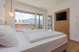 a bedroom with a white bed and a large window at Laurena Aparthotel near Brixen in Natz-Schabs +58 photos