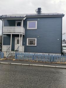 a blue house with a blue fence in front of it at Room 2 in Kirkenes