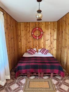 a bedroom with a bed in a wooden wall at Dacha Marella in Nova Dofinivka