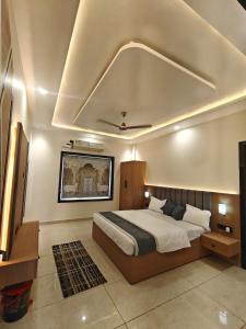 a bedroom with a large bed and a ceiling at Hotel Brijraj Dham in Govardhan