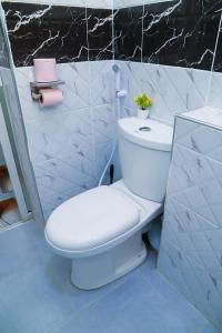 a white toilet in a bathroom with a black wall at GLOW Suites in Naivasha +23 photos