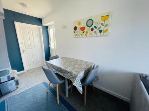 a dining room with a table and chairs in a room at Godrevy Lighthouse View, Carbis Bay, St Ives, free parking, sea view in Carbis Bay