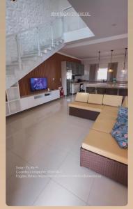 a large living room with couches and a tv at Refúgio Tropical in Touros