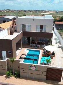 a villa with a swimming pool and a house at Refúgio Tropical in Touros