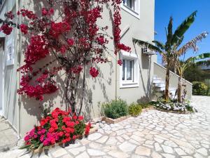 una casa con fiori rossi su un lato di Morfi a Città di Lefkada