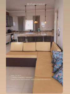 a living room with a couch and a kitchen at Refúgio Tropical in Touros