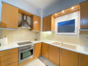 a kitchen with wooden cabinets and a sink and a window at Olyvia in Plaka Litochorou +10 photos