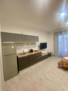 a kitchen with a sink and a couch in a room at Casa vacanza La Ninfea intera casa in Caltagirone