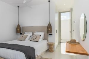 a white bedroom with a bed and a mirror at THEIA VILLA in Adamantas +24 photos