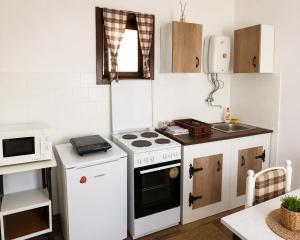 a small kitchen with a stove and a microwave at Kuća iz zavičaja in Kuršumlija