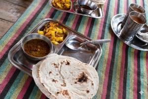 a tray of food with a tortilla and other foods at Shanta Ghar A Rustic Guesthouse in Chitwan