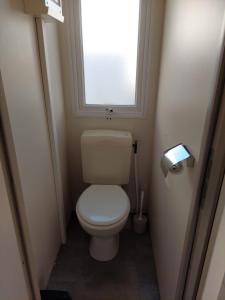 a small bathroom with a toilet with a window at Cantinho da Rosa in Pataias +5 photos