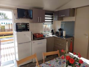 a kitchen with a white refrigerator and a table at Cantinho da Rosa in Pataias