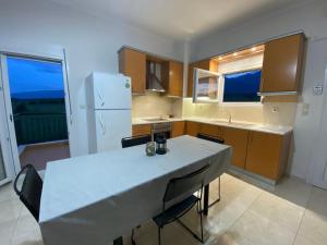 a kitchen with a table with chairs and a refrigerator at Olyvia in Plaka Litochorou