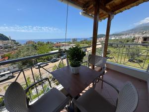 a table and chairs on a balcony with a view of the ocean at Rexhos Studios in Himare
