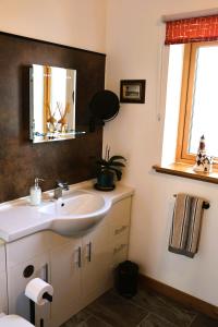 a bathroom with a sink and a mirror at Modern, eco friendly house in Kildonan on Skye in Flashader +24 photos