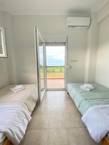 two beds in a room with a view of the ocean at Olyvia in Plaka Litochorou