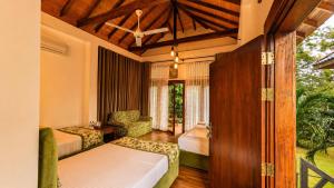 a bedroom with a bed and a chair in a room at Gatetrees resort in Jaffna