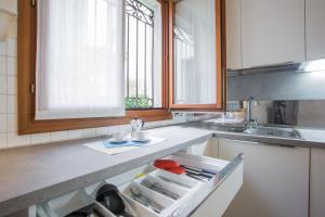 una cucina con lavandino e cassetto aperto di Filodrammatici Loft by Welc(H)ome a Treviso