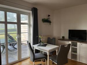 a dining room with a table and chairs and a window at Landhaus Baumhöfer in Apen