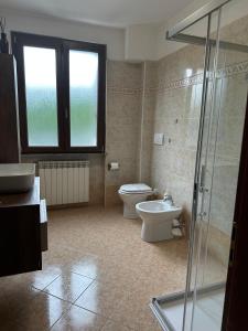 a bathroom with a toilet and a sink and a shower at Casa del Melograno Outlet in Serravalle Scrivia +17 photos
