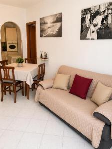 a living room with a couch and a table at MARINE KISS- Appartamento con PARCHEGGIO PRIVATO GRATUITO- Vicino Porto Crociere e Stazione in Civitavecchia