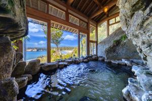 a large pool of water in a house with windows at 鵜原館 -Ubarakan- in Katsuura