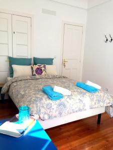 a bedroom with a bed with blue pillows on it at Lisbonera Guest House in Lisbon
