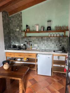a kitchen with a white refrigerator and a table at Casita de Piedra in Atyrá