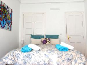 um quarto com uma cama com cobertores azuis e brancos em Lisbonera Guest House em Lisboa