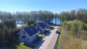 an overhead view of a row of houses with blue roofs at domki pod Jesionem Sławianowo nad jeziorem in Sławianowo