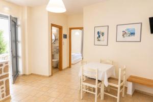 a dining room with a table and chairs and a bathroom at Filoxenia Apartments in Adamantas