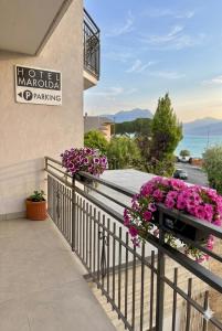 ein Balkon mit rosa Blumen an einem Gebäude in der Unterkunft Hotel Marolda in Sirmione
