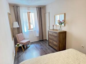 a bedroom with a bed and a dresser and a chair at Gloria apartment Rovinj - Heart of Old town - Steps from Sea in Rovinj