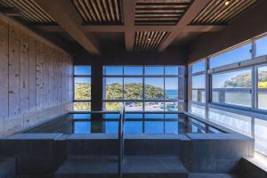 a swimming pool with a view of the ocean at 鵜原館 -Ubarakan- in Katsuura