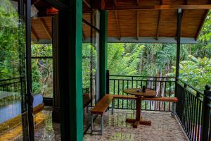 a porch with a wooden table and a bench at Nice View Guest House & Restaurant in Ella