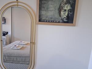 a mirror with a picture of a man on a bed at LENNON SUITE remis free Ezeiza in Ezeiza