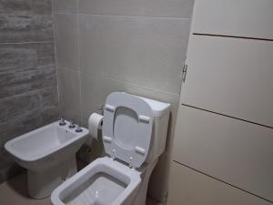 a bathroom with a toilet and a sink at LENNON SUITE remis free Ezeiza in Ezeiza +7 photos