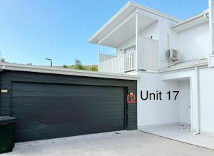 a black garage door on a white house at 17 Pimpama Home in Pimpama