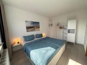 a bedroom with a bed with a blue comforter at SELTEN Wasserblick Kölpinsee - Tolle Ferienwohnung unter 500m zur Ostsee Kajüte 12 in Kölpinsee