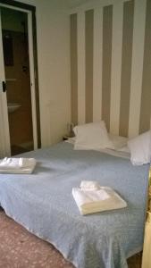a bedroom with a bed with two towels on it at Bed Il Faro in Finale Ligure
