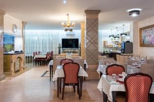 a restaurant with tables and chairs and a fireplace at HOTEL ROYAL Paris Ivry in Ivry-sur-Seine