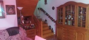 a living room with a staircase and a wooden cabinet at Casa Bunicilor in Moldoviţa +6 photos