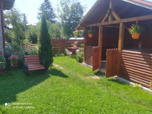 a garden with a bench and a gazebo at Casa Bunicilor in Moldoviţa