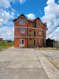 a large orange house on the side of a road at Hotel Doina 1 Tășnad in Tăşnad