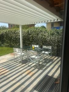 a glass table and chairs on a patio at LUXURY vertical open space in Sangiano