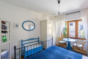 a bedroom with a blue bed and a table at Il Cortile di Mamma Mia in Pisano